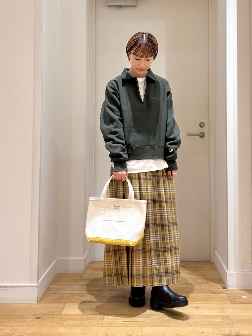 グリーン系のスウェット、イエロー系のスカート、ホワイト系のTシャツ/カットソーを着用したレディースの秋コーディネートの3枚目の写真