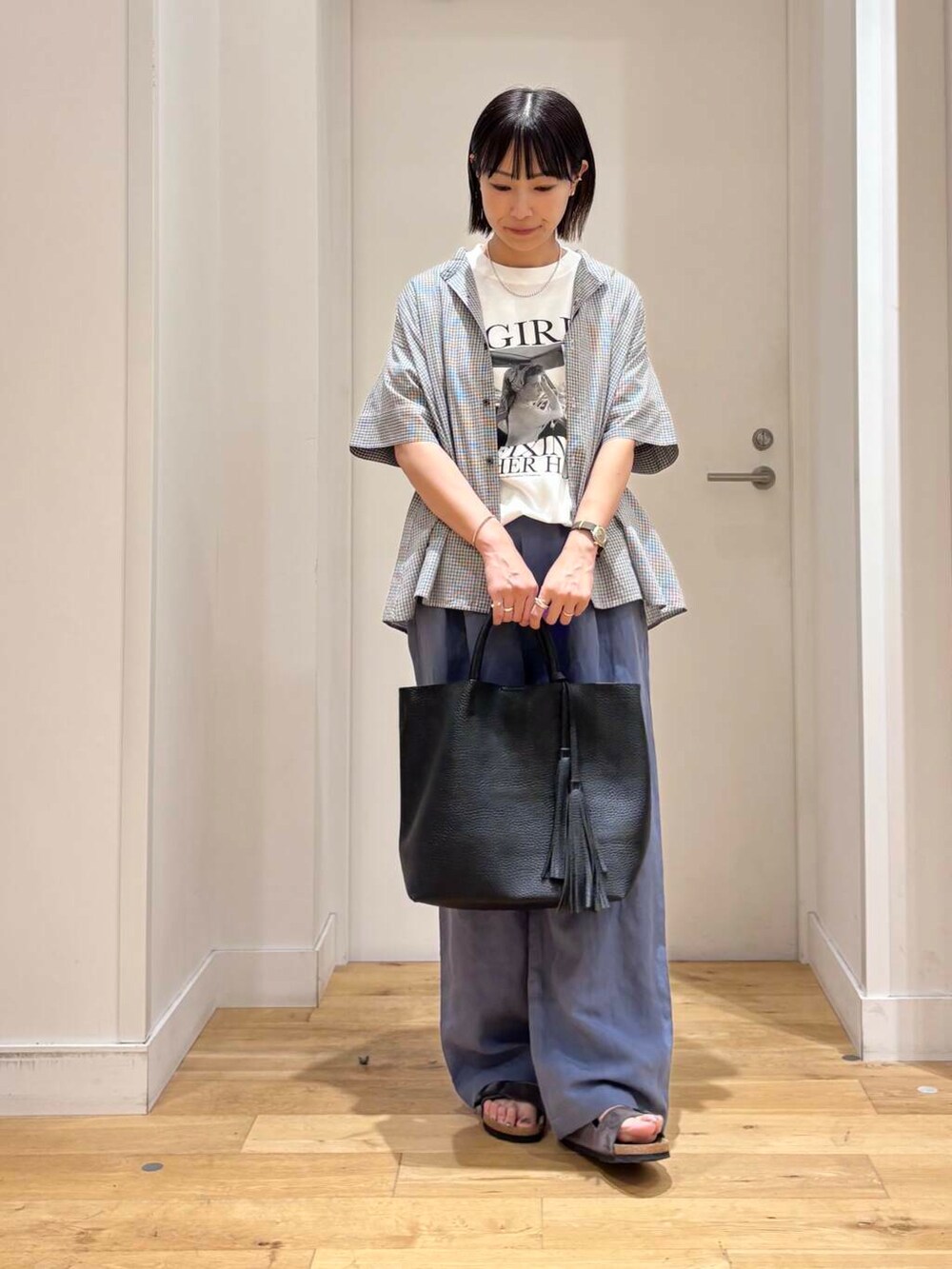 ブラック系のトートバッグ、グレー系のサンダル、ブルー系のその他パンツを着用したレディースの夏コーディネートの5枚目の写真