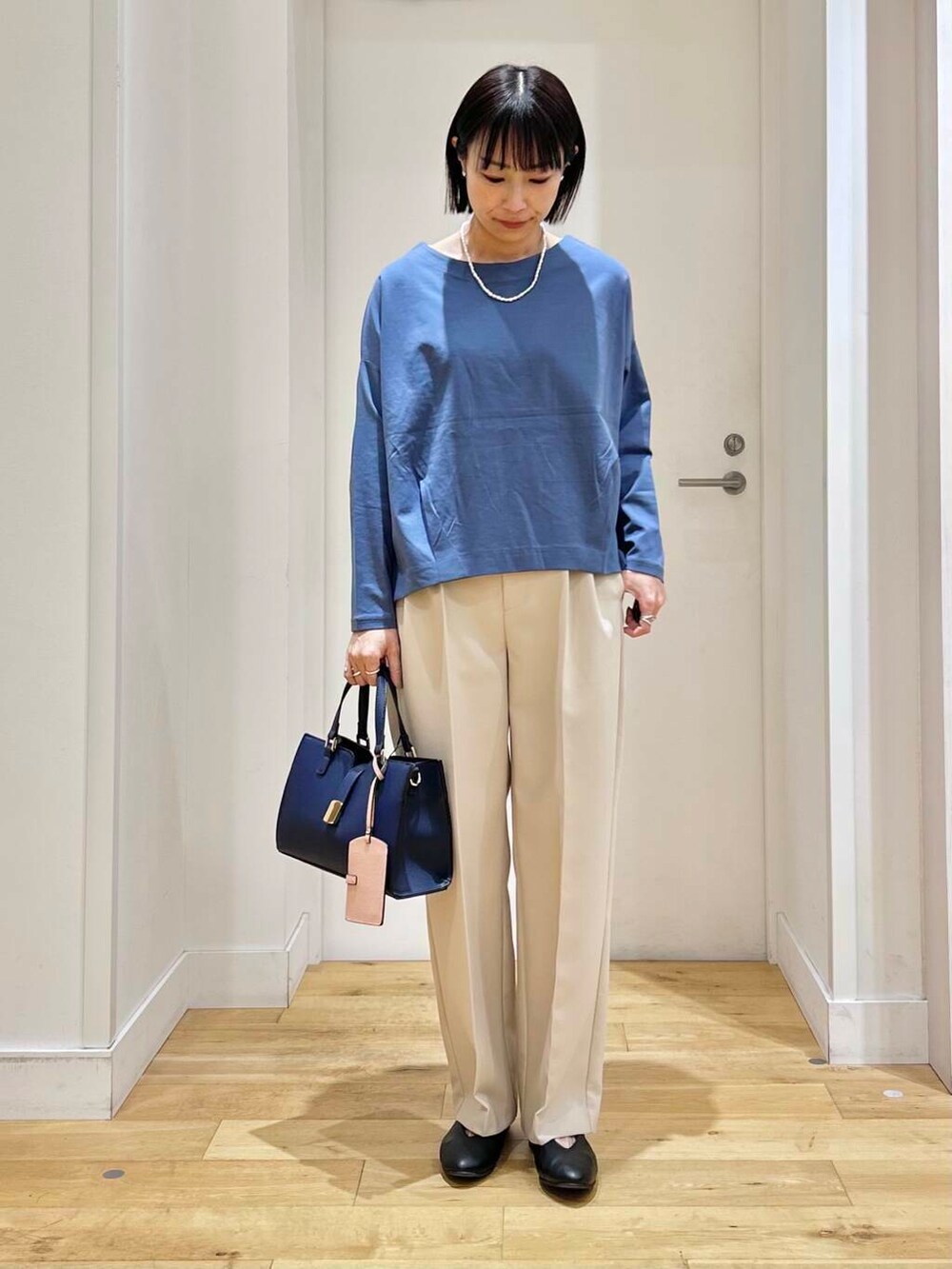 ブルー系のTシャツ/カットソー、ホワイト系のその他パンツ、ブラック系のパンプスを着用したレディースの冬コーディネートの6枚目の写真