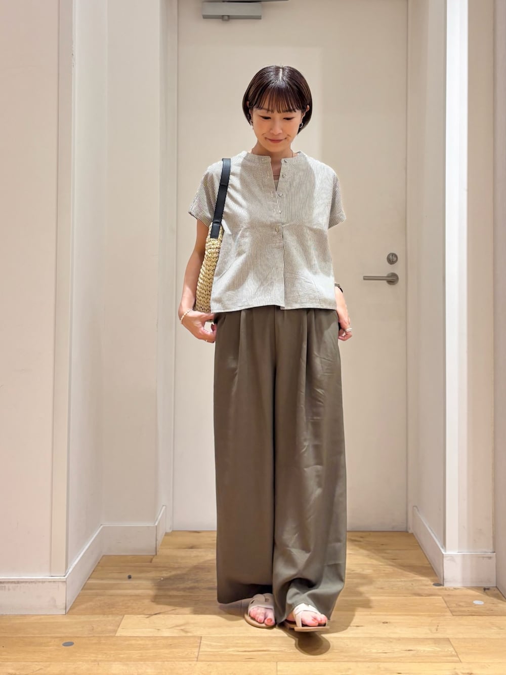 ブラック系のシャツ/ブラウス、グリーン系のその他パンツ、ベージュ系のトートバッグを着用したレディースの夏コーディネートの2枚目の写真