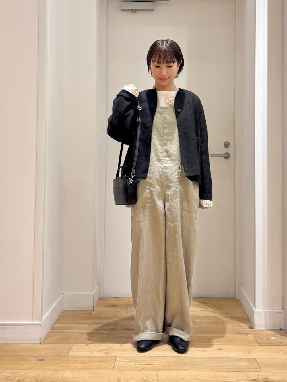 ホワイト系のシャツ/ブラウス、グレー系のサロペット/オーバーオール、ブラック系のその他シューズを着用したレディースの春コーディネートの2枚目の写真