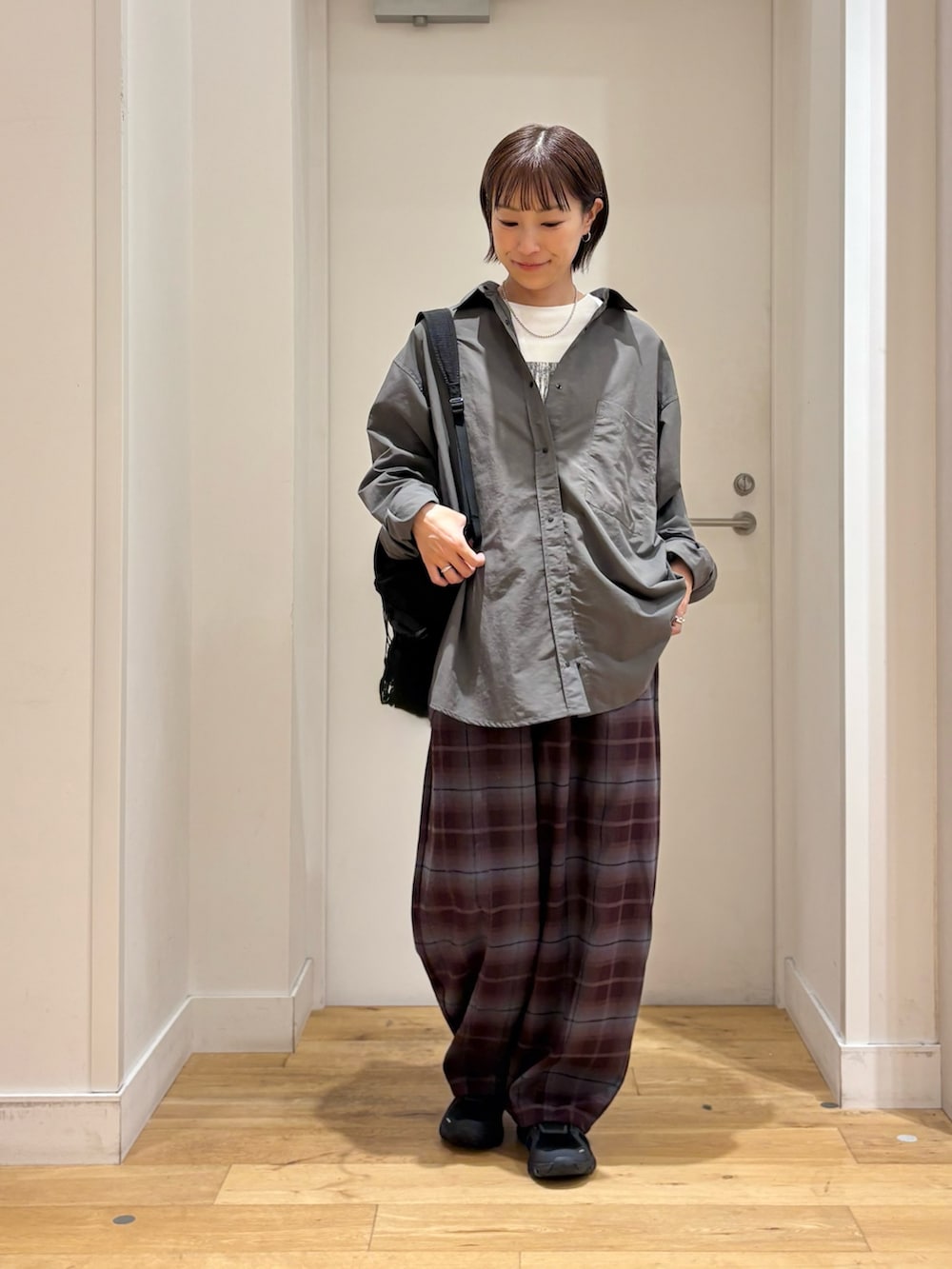 ブラック系のバックパック/リュック、グレー系のシャツ/ブラウス、パープル系のその他パンツを着用したレディースの秋コーディネートの2枚目の写真