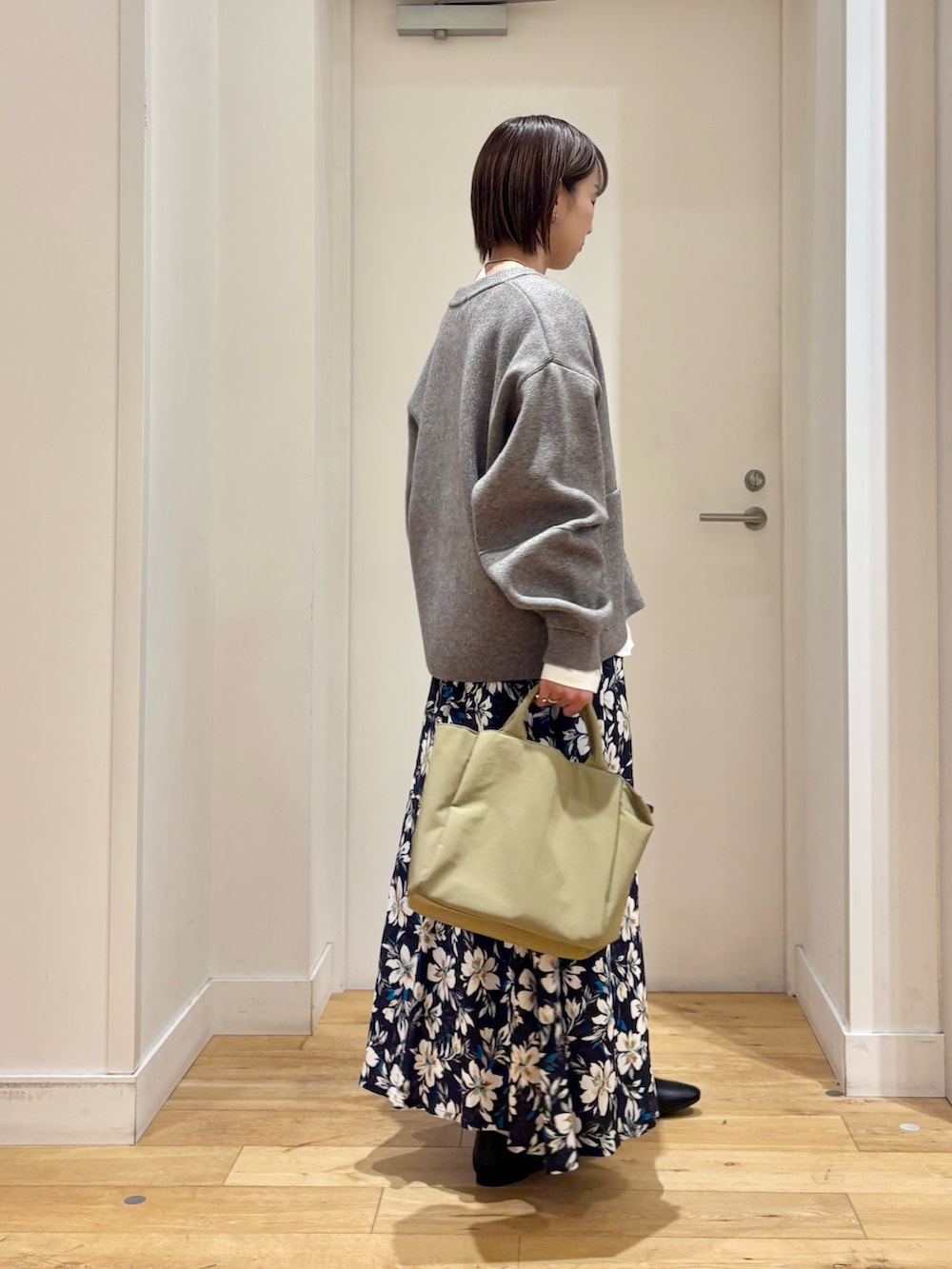 グリーン系のニット/セーター、ホワイト系のTシャツ/カットソー、ブルー系のスカートを着用したレディースの冬コーディネートの5枚目の写真