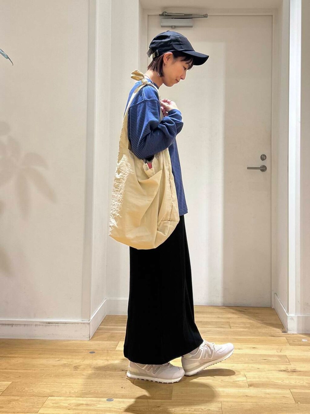 グレー系のショルダーバッグ、ブラック系のスカート、グレー系のスニーカーを着用したレディースの夏コーディネートの4枚目の写真