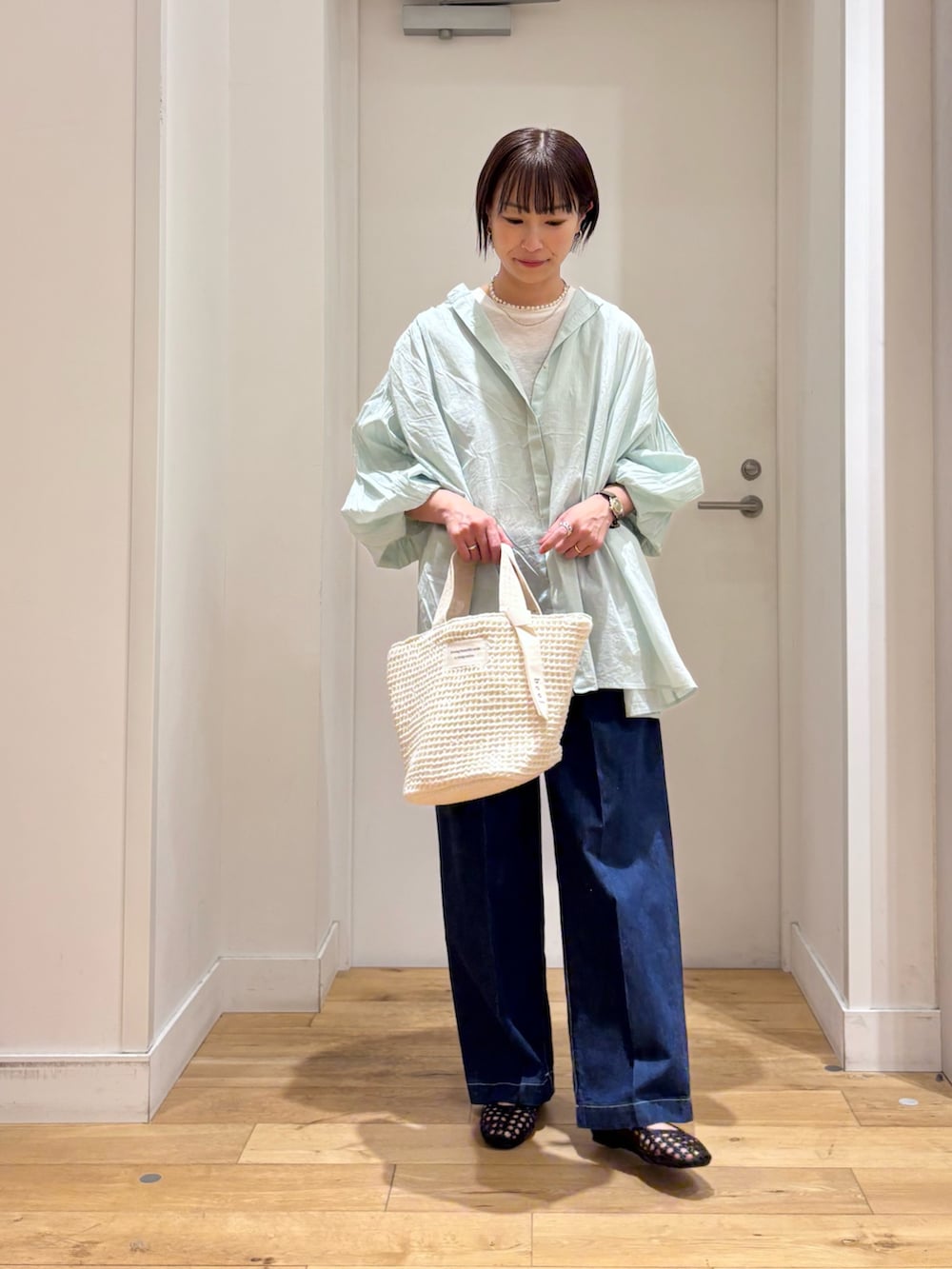 グリーン系のシャツ/ブラウス、ホワイト系のTシャツ/カットソー、ブルー系のデニムパンツを着用したレディースの春コーディネートの3枚目の写真