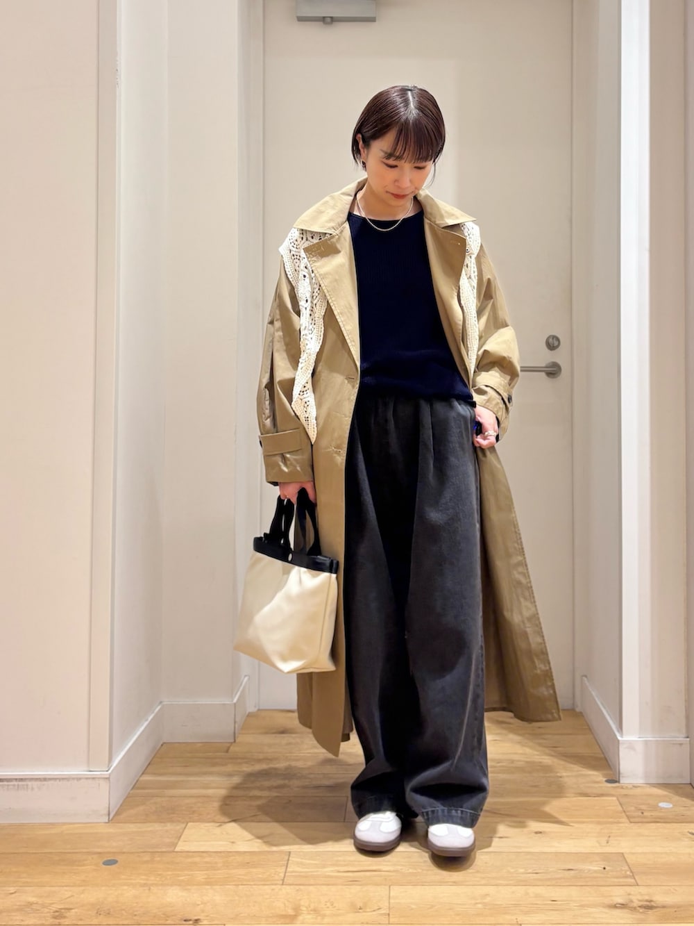 ブルー系のニット/セーター、ブラック系のデニムパンツ、ホワイト系のハンドバッグを着用したレディースの春コーディネートの4枚目の写真