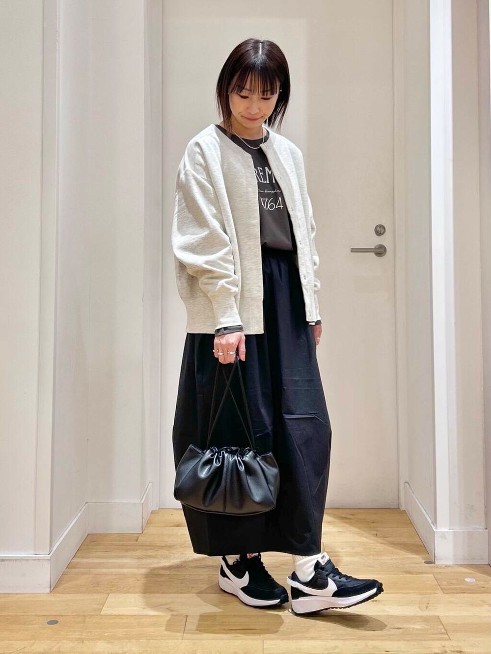 グレー系のTシャツ/カットソー、ブラック系のショルダーバッグ、ベージュ系のカーディガン/ボレロを着用したレディースの冬コーディネートの3枚目の写真