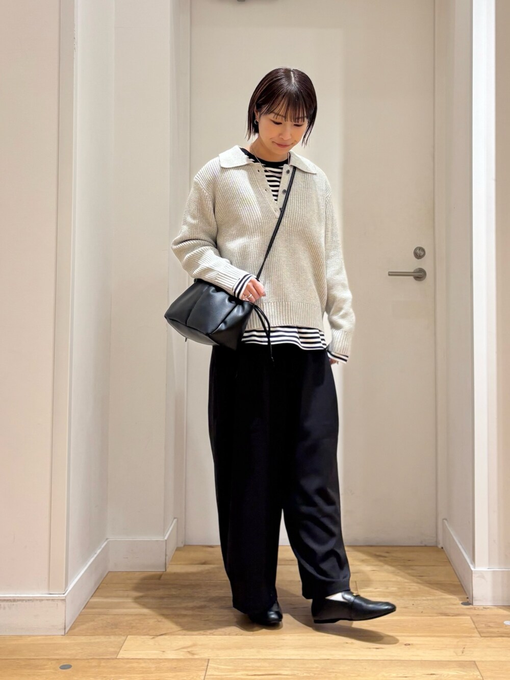 グレー系のニット/セーター、ホワイト系のTシャツ/カットソー、ブラック系のその他パンツを着用したレディースの冬コーディネートの4枚目の写真