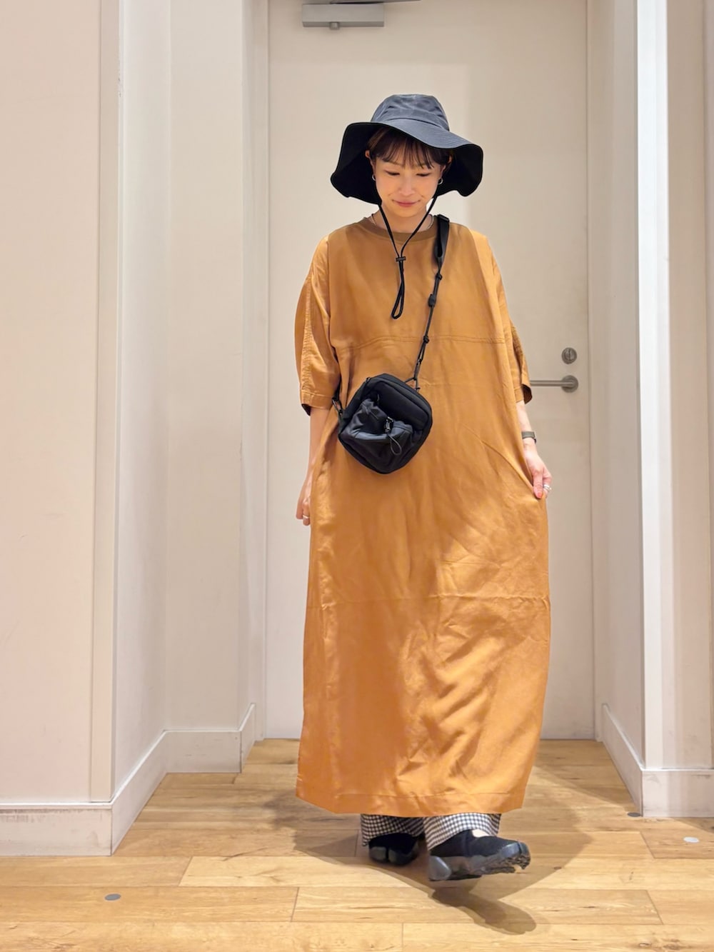 イエロー系のワンピース、ブラック系のショルダーバッグ、ブラック系のその他パンツを着用したレディースの夏コーディネートの3枚目の写真