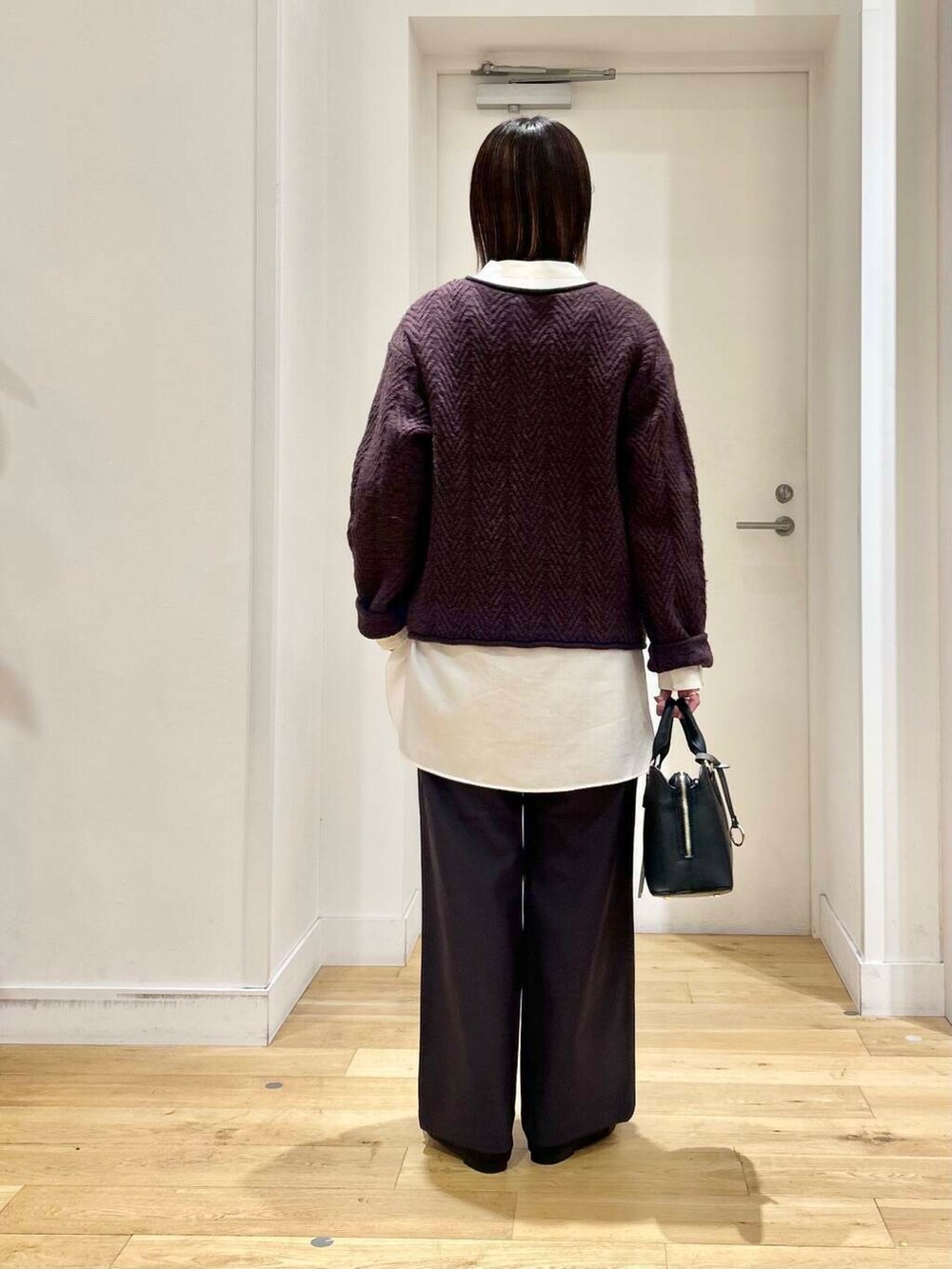 ブラック系のドレスシューズ、ホワイト系のシャツ/ブラウス、ブラック系のハンドバッグを着用したレディースの冬コーディネートの6枚目の写真