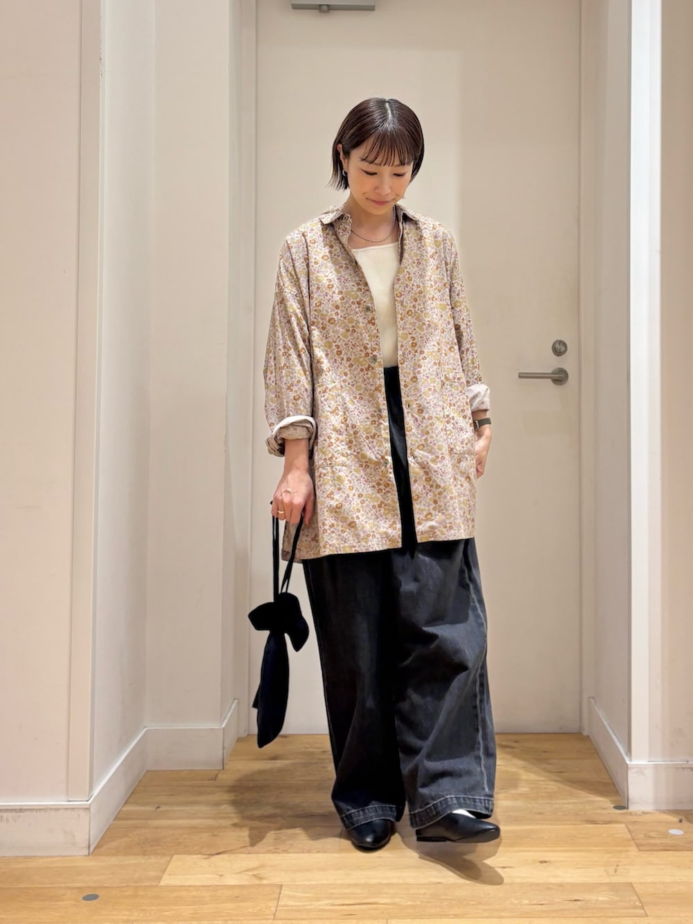ピンク系のシャツ/ブラウス、ホワイト系のタンクトップ、ブラック系のデニムパンツを着用したレディースの秋コーディネートの4枚目の写真