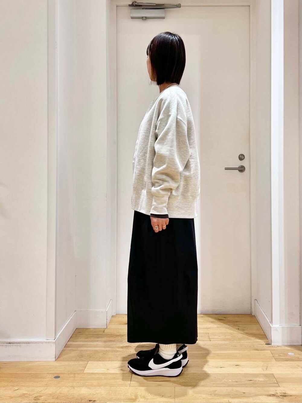 グレー系のTシャツ/カットソー、ブラック系のショルダーバッグ、ベージュ系のカーディガン/ボレロを着用したレディースの冬コーディネートの4枚目の写真