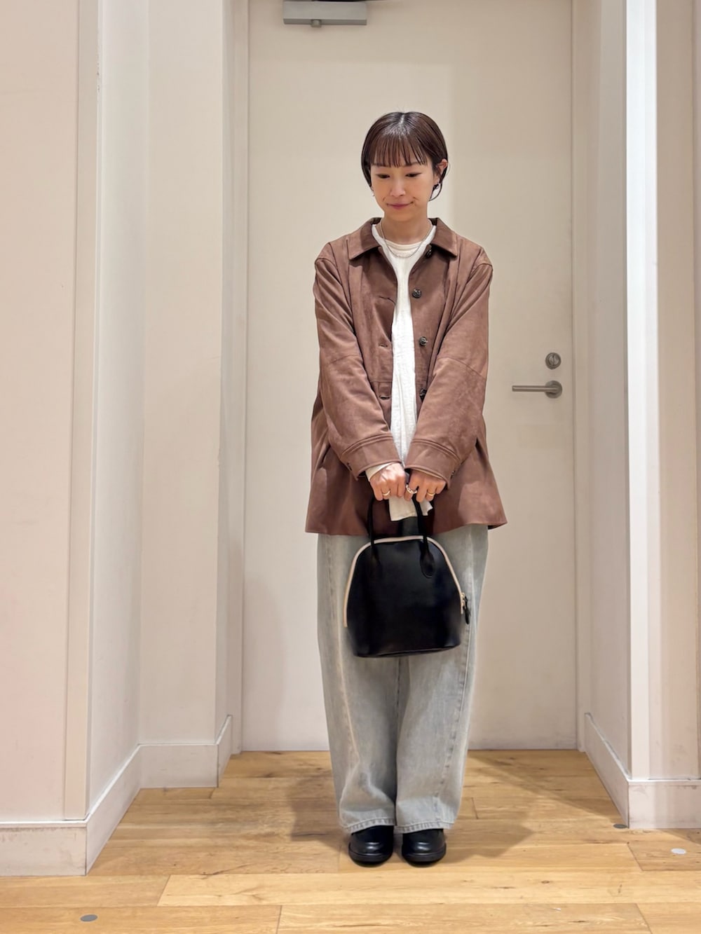 ブラウン系のテーラードジャケット、ホワイト系のシャツ/ブラウス、ブルー系のデニムパンツを着用したレディースの秋コーディネートの3枚目の写真