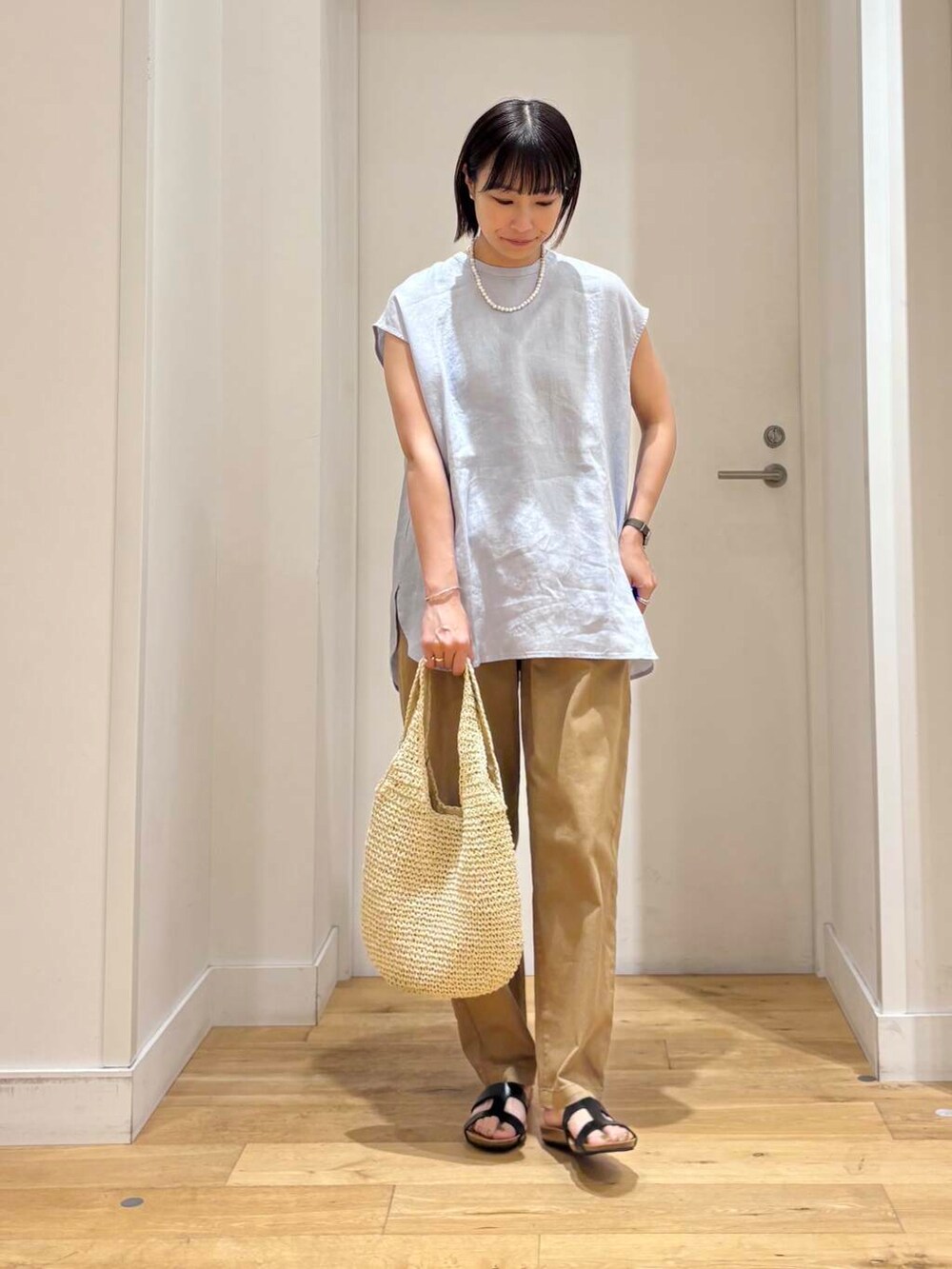 ベージュ系のトートバッグ、ベージュ系のその他パンツ、ブルー系のシャツ/ブラウスを着用したレディースの夏コーディネートの2枚目の写真