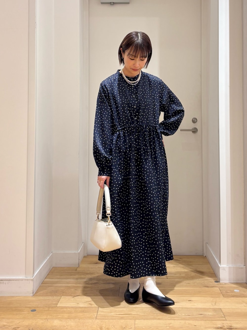 ブルー系のワンピース、グレー系のその他アウター、ホワイト系のショルダーバッグを着用したレディースの冬コーディネートの7枚目の写真