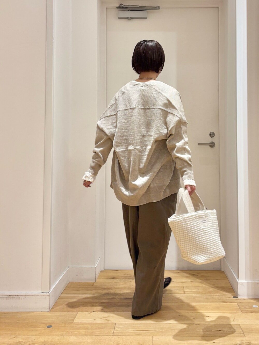 ホワイト系のTシャツ/カットソー、ベージュ系のカーディガン/ボレロ、グリーン系のサロペット/オーバーオールを着用したレディースの春コーディネートの6枚目の写真