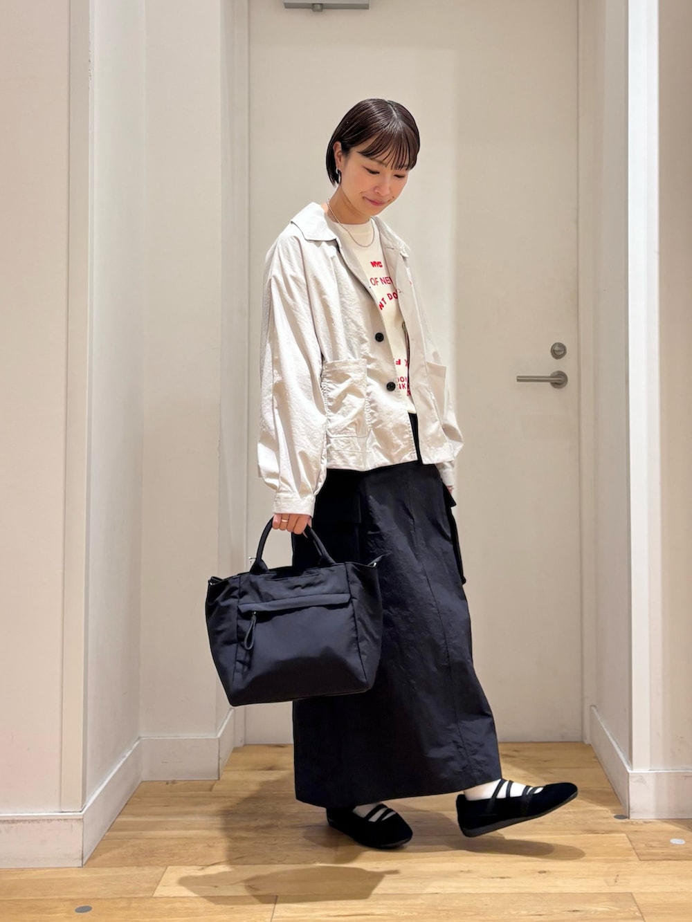 ホワイト系のTシャツ/カットソー、ベージュ系のテーラードジャケット、ブラック系のスカートを着用したレディースの春コーディネートの4枚目の写真