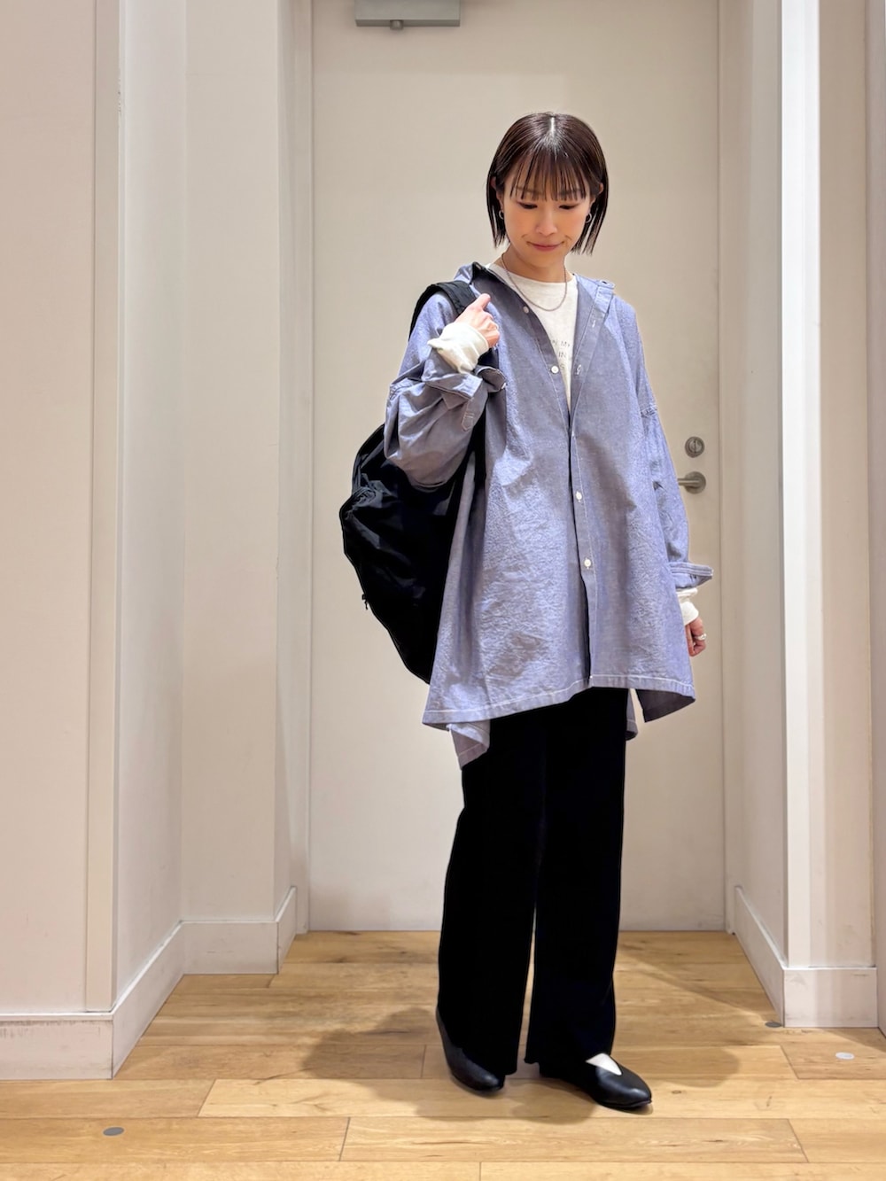 ブラック系のその他パンツ、ブラック系のパンプス、ブルー系のシャツ/ブラウスを着用したレディースの冬コーディネートの4枚目の写真