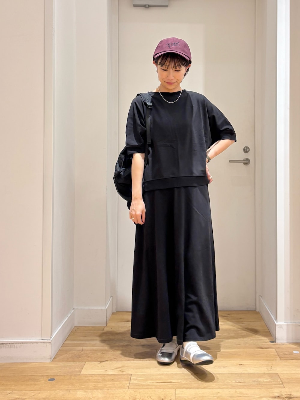 ブラック系のTシャツ/カットソー、ブラック系のバックパック/リュック、シルバー系のスニーカーを着用したレディースの春コーディネートの3枚目の写真