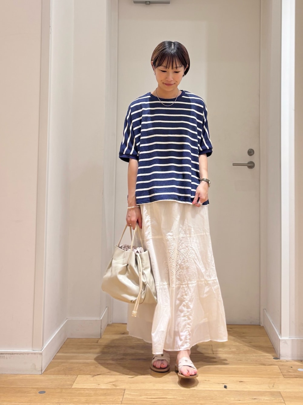 ブルー系のTシャツ/カットソー、ホワイト系のスカート、ホワイト系のショルダーバッグを着用したレディースの夏コーディネートの2枚目の写真