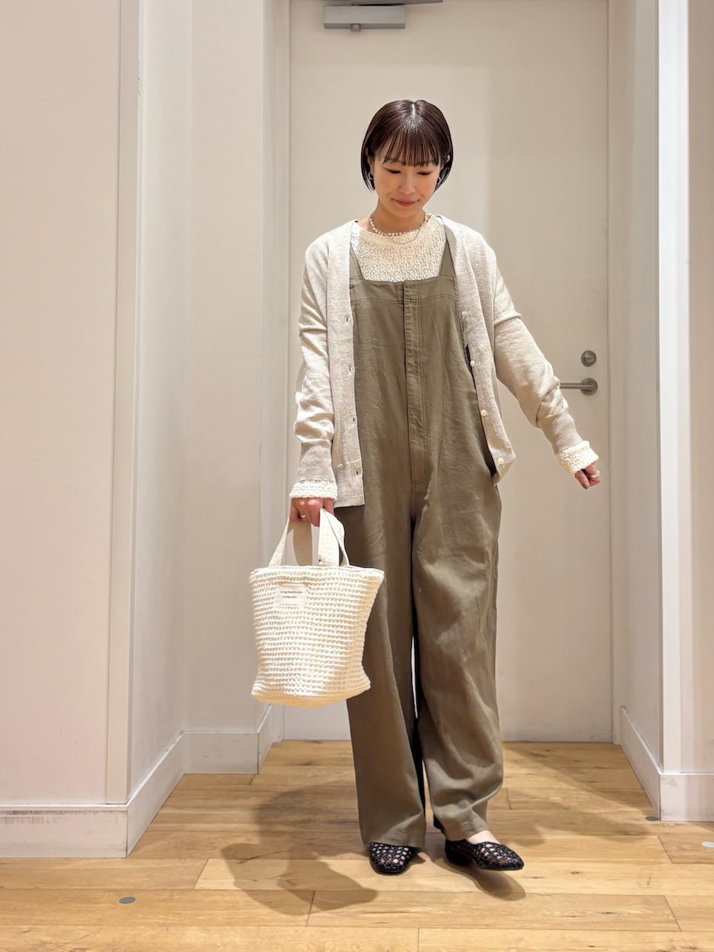 ホワイト系のTシャツ/カットソー、ベージュ系のカーディガン/ボレロ、グリーン系のサロペット/オーバーオールを着用したレディースの春コーディネートの3枚目の写真