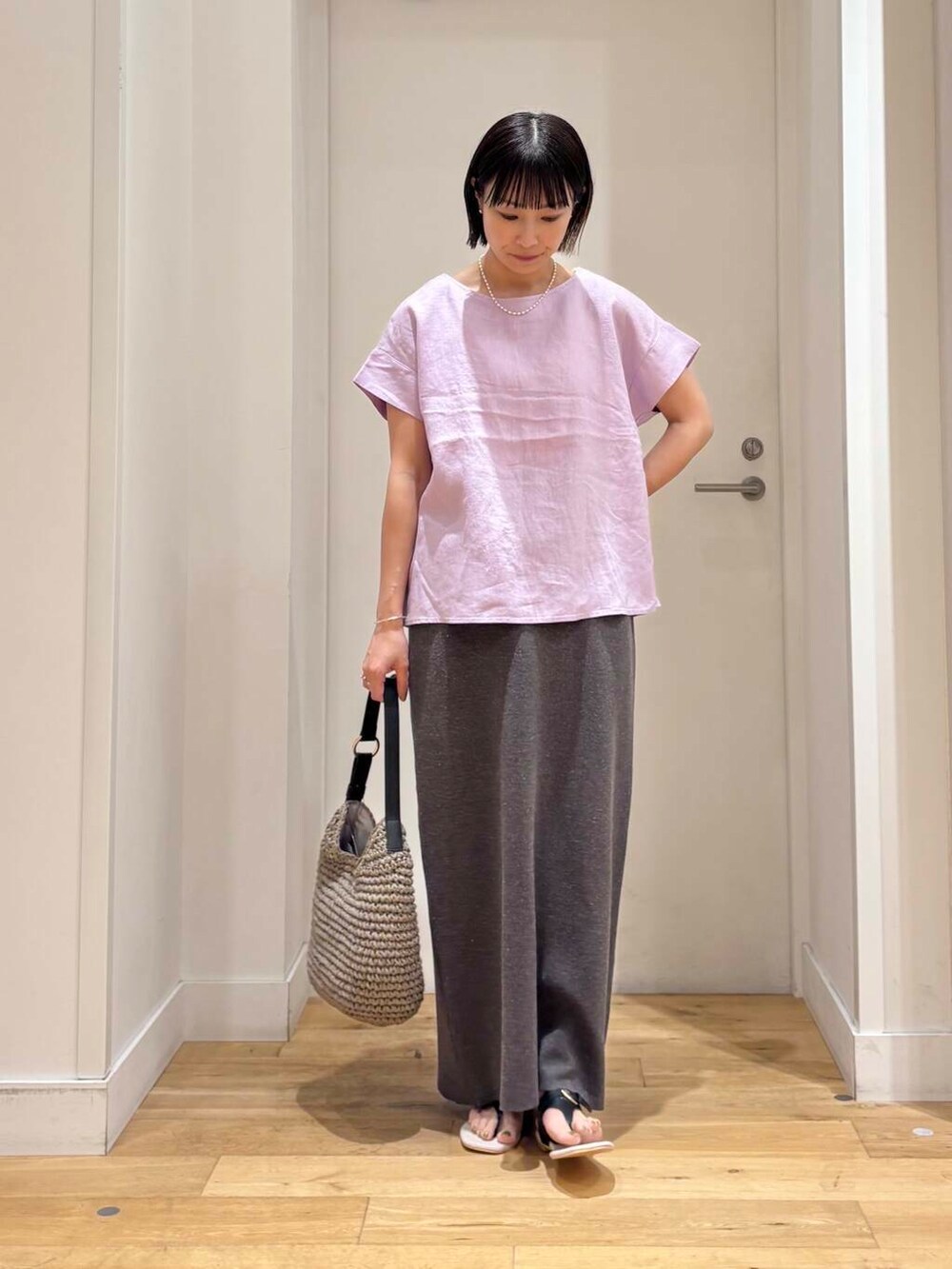 グレー系のトートバッグ、ブラック系のサンダル、グレー系のスカートを着用したレディースの夏コーディネートの2枚目の写真