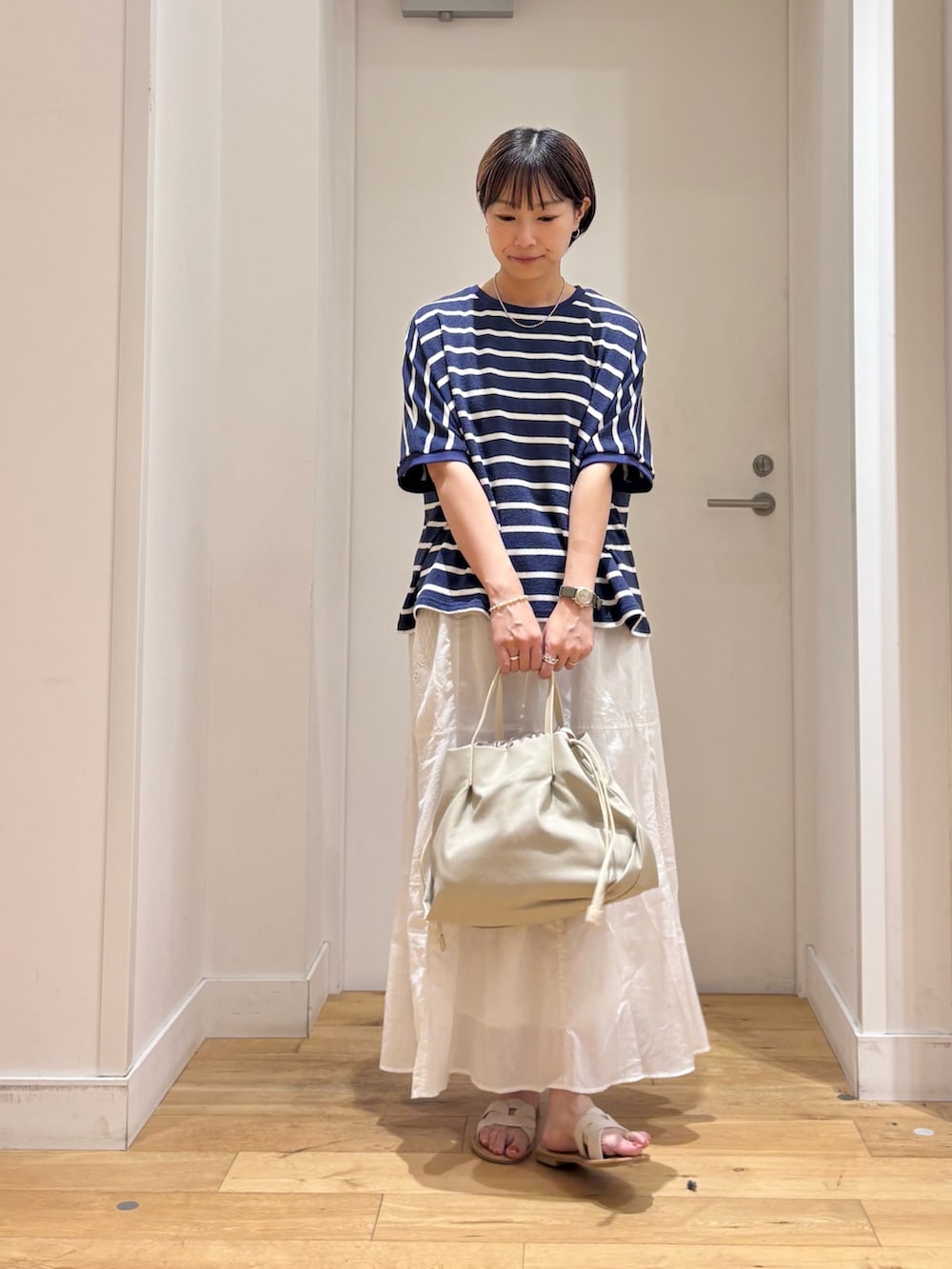 ブルー系のTシャツ/カットソー、ホワイト系のスカート、ホワイト系のショルダーバッグを着用したレディースの夏コーディネートの4枚目の写真