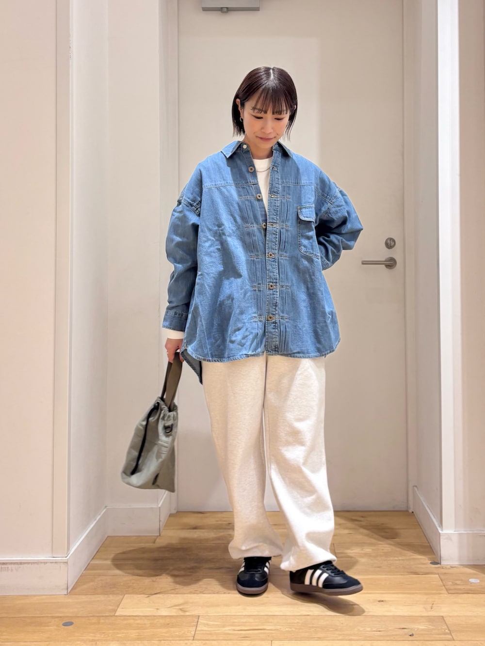 グレー系のその他パンツ、ブルー系のショルダーバッグ、ブラック系のスニーカーを着用したレディースの冬コーディネートの2枚目の写真