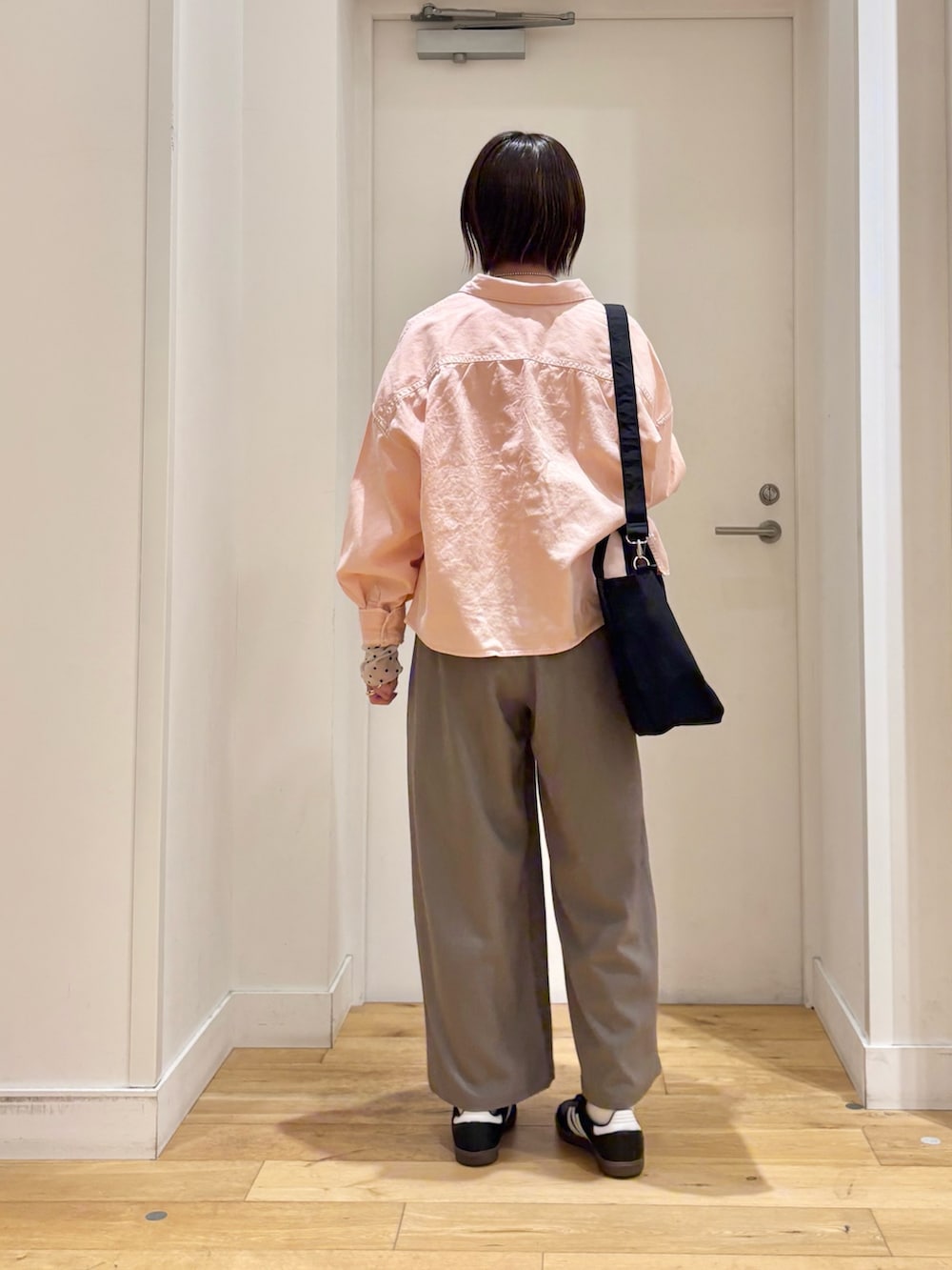 ピンク系のシャツ/ブラウス、ホワイト系のTシャツ/カットソー、ブラック系のスニーカーを着用したレディースの冬コーディネートの5枚目の写真