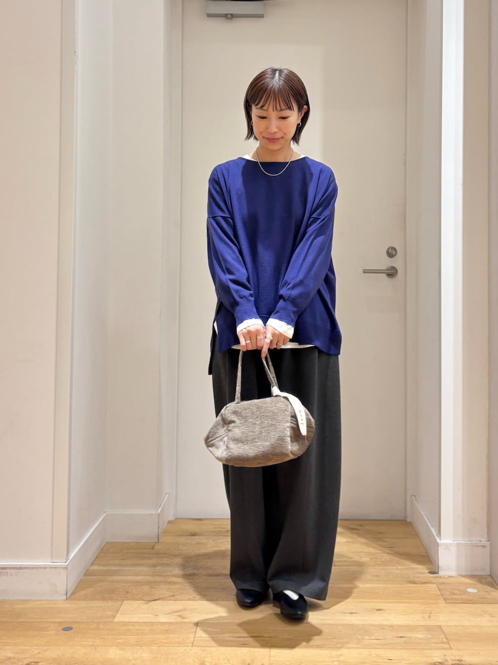 ブルー系のニット/セーター、グレー系のその他パンツ、ブラック系のパンプスを着用したレディースの秋コーディネートの3枚目の写真