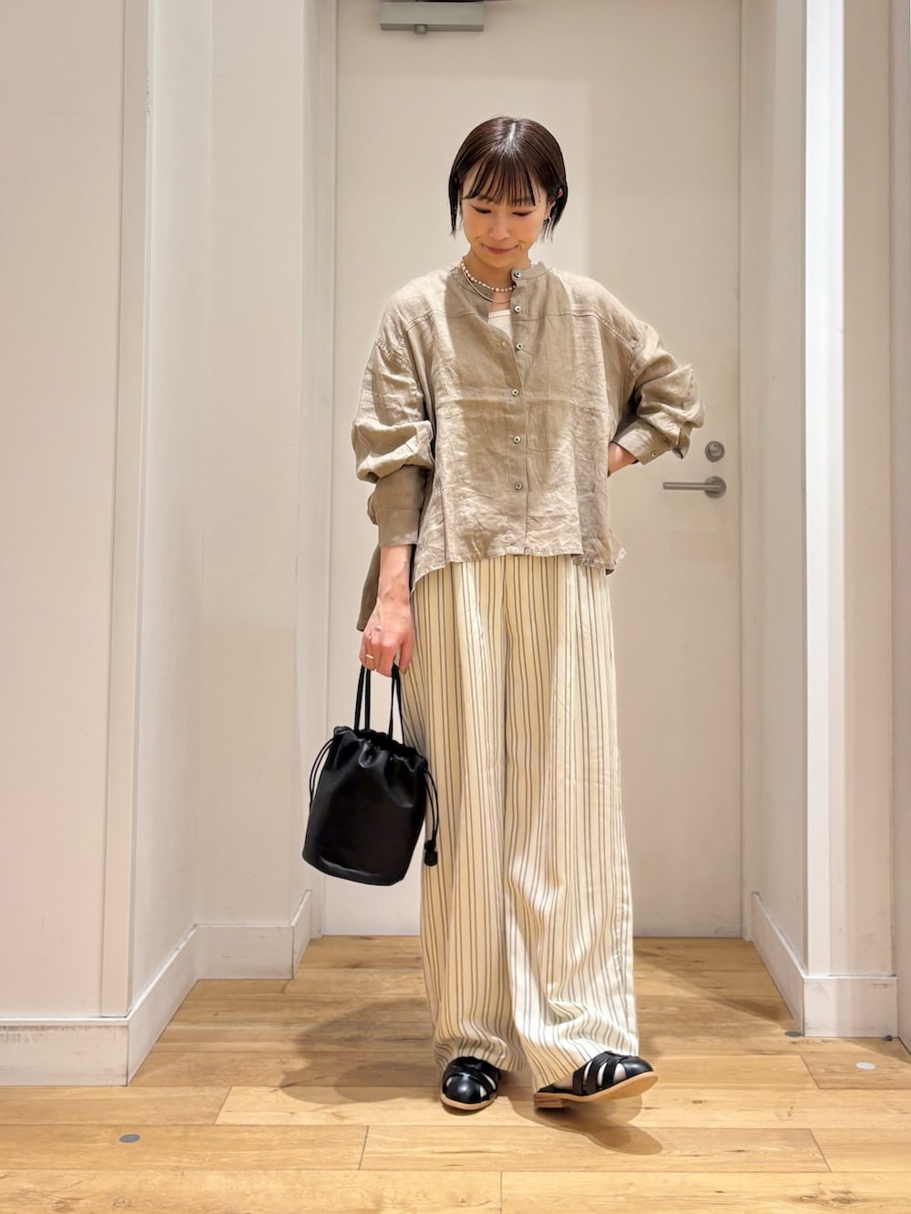 ブラウン系のシャツ/ブラウス、ホワイト系のタンクトップ、ベージュ系のその他パンツを着用したレディースの春コーディネートの3枚目の写真