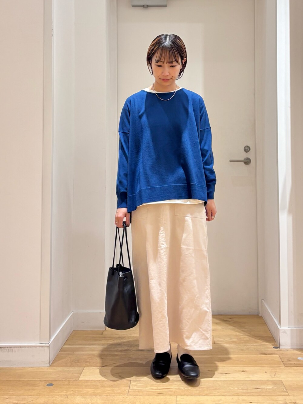 グレー系のその他アウター、ブルー系のニット/セーター、ブラック系のショルダーバッグを着用したレディースの秋コーディネートの5枚目の写真