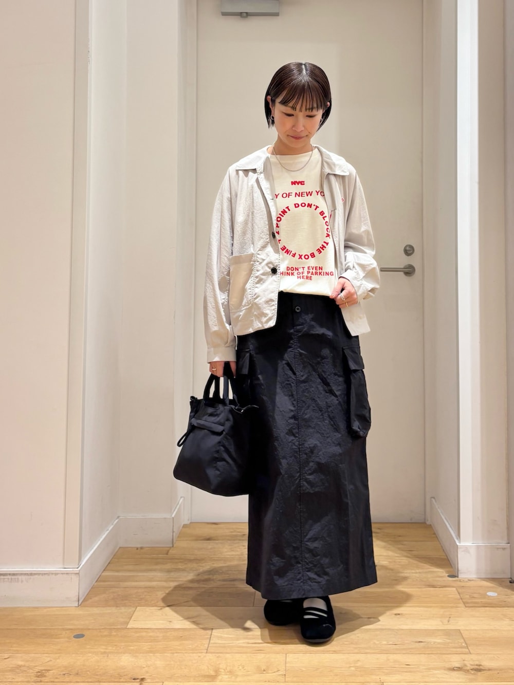 ホワイト系のTシャツ/カットソー、ベージュ系のテーラードジャケット、ブラック系のスカートを着用したレディースの春コーディネートの2枚目の写真