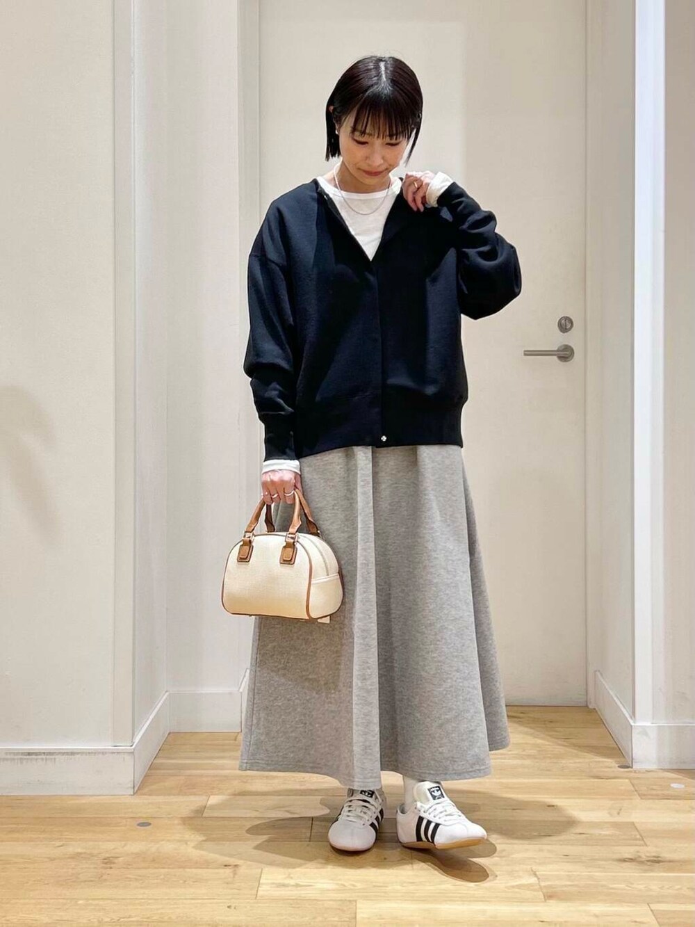 ホワイト系のTシャツ/カットソー、グレー系のスカート、ホワイト系のスニーカーを着用したレディースの冬コーディネートの2枚目の写真