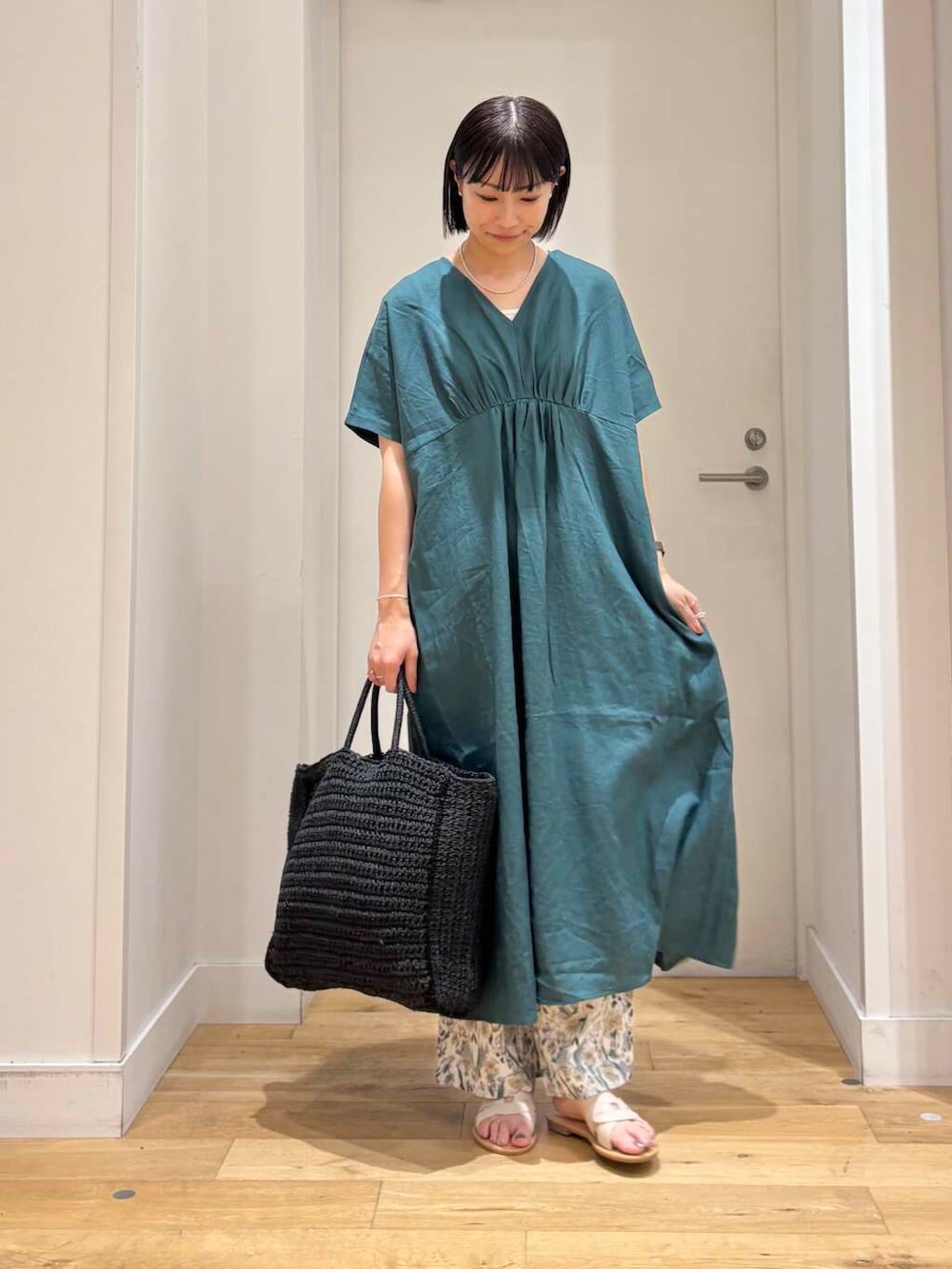 ブラック系のトートバッグ、ホワイト系のサンダル、ベージュ系のその他パンツを着用したレディースの夏コーディネートの2枚目の写真