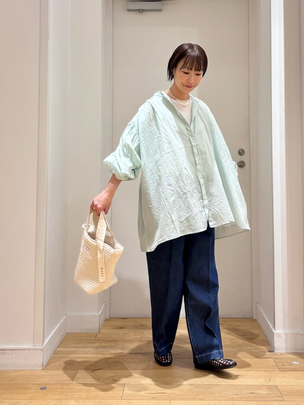 グリーン系のシャツ/ブラウス、ホワイト系のTシャツ/カットソー、ブルー系のデニムパンツを着用したレディースの春コーディネートの5枚目の写真