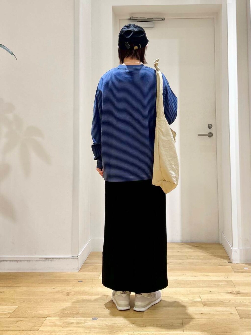 グレー系のショルダーバッグ、ブラック系のスカート、グレー系のスニーカーを着用したレディースの夏コーディネートの5枚目の写真