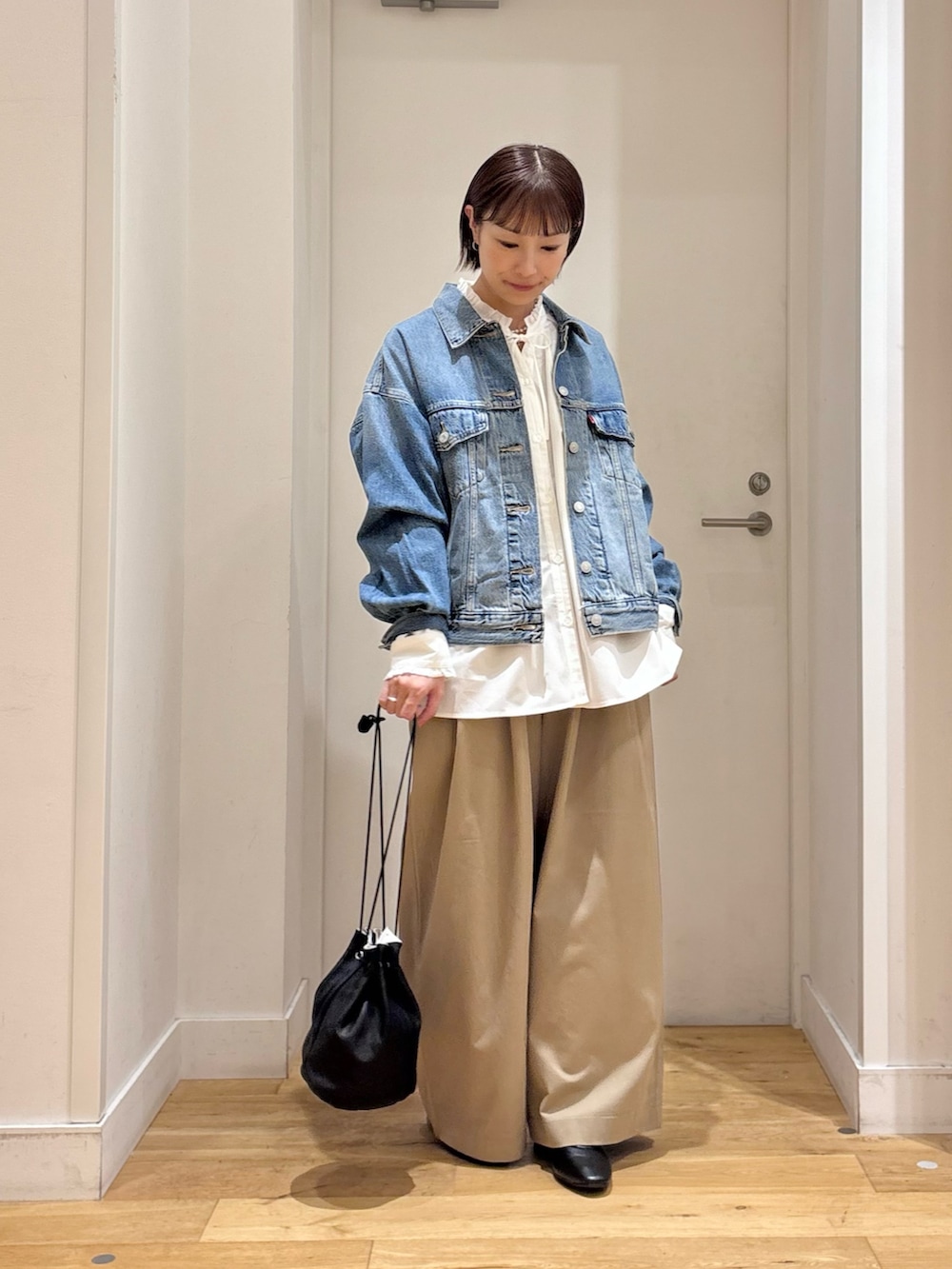 ホワイト系のシャツ/ブラウス、ブルー系のデニムジャケット、ベージュ系のその他パンツを着用したレディースの秋コーディネートの5枚目の写真
