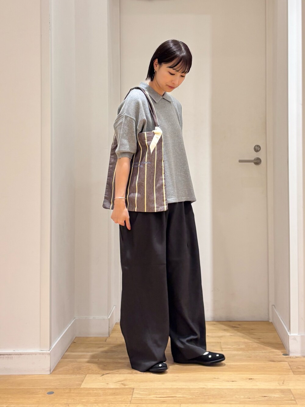 ブラック系のその他パンツ、グレー系のニット/セーター、ブラック系のスニーカーを着用したレディースの秋コーディネートの4枚目の写真