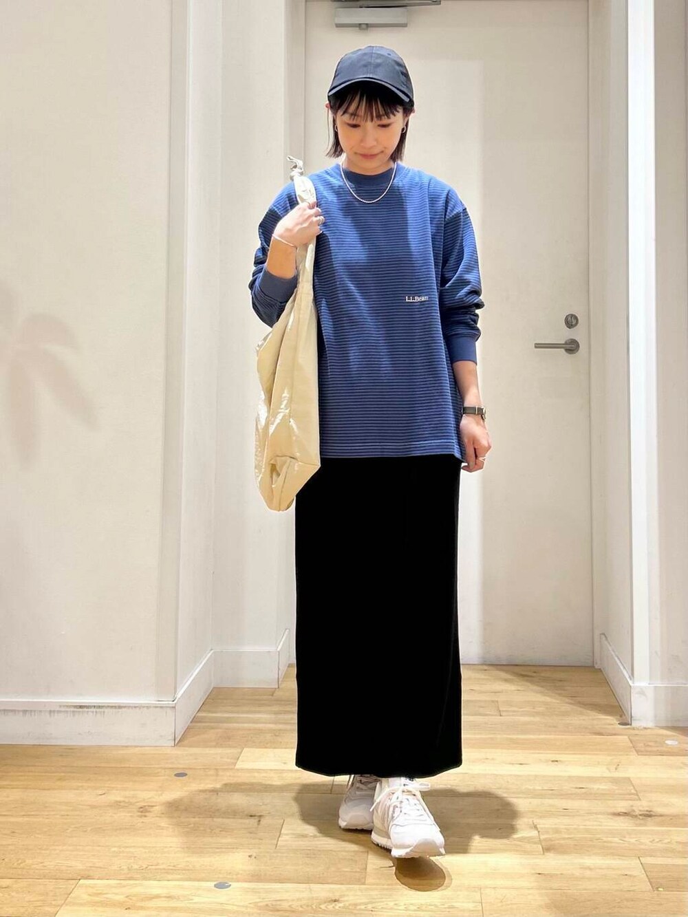 グレー系のショルダーバッグ、ブラック系のスカート、グレー系のスニーカーを着用したレディースの夏コーディネートの3枚目の写真