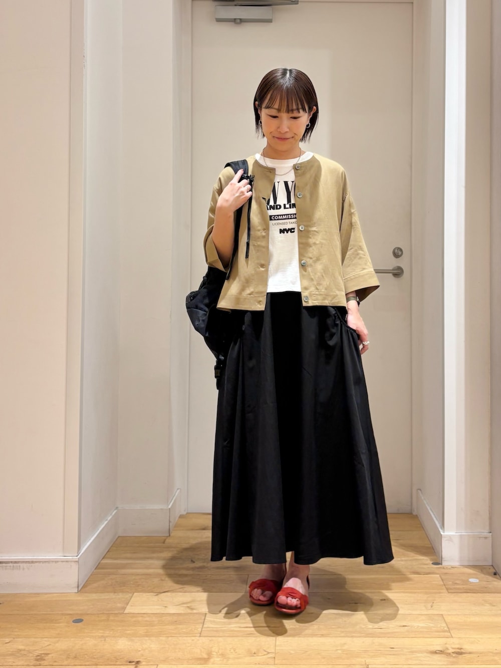 ベージュ系のシャツ/ブラウス、ブラック系のスカート、ホワイト系のTシャツ/カットソーを着用したレディースの春コーディネートの4枚目の写真
