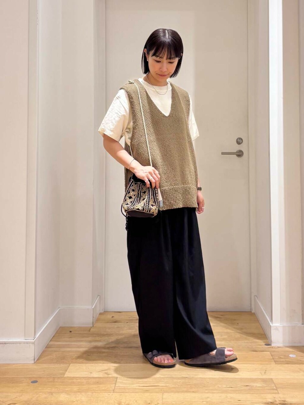 ホワイト系のシャツ/ブラウス、グレー系のサンダル、ブラック系のショルダーバッグを着用したレディースの夏コーディネートの4枚目の写真