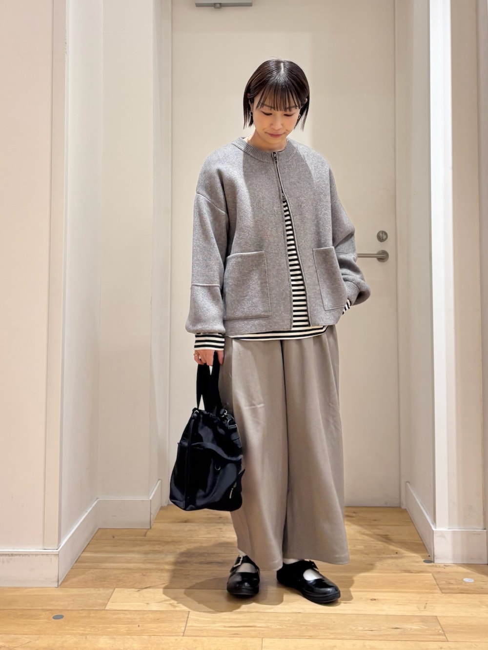 グリーン系のニット/セーター、ホワイト系のTシャツ/カットソー、グレー系のその他パンツを着用したレディースの冬コーディネートの2枚目の写真