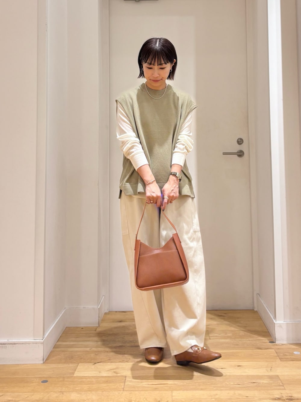 ホワイト系のTシャツ/カットソー、ブラウン系のハンドバッグを着用したレディースの夏コーディネートの2枚目の写真
