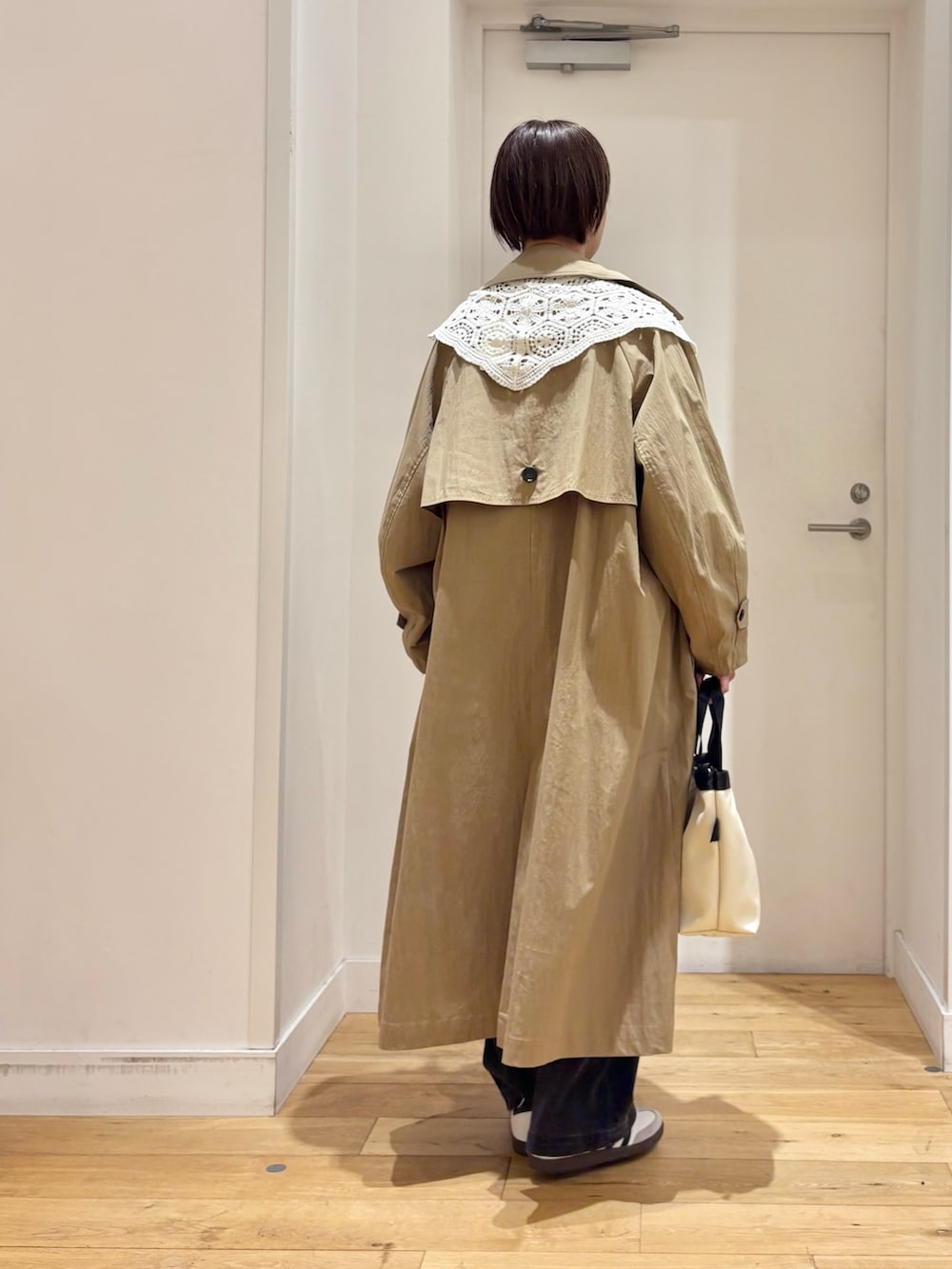 ブルー系のニット/セーター、ブラック系のデニムパンツ、ホワイト系のハンドバッグを着用したレディースの春コーディネートの6枚目の写真