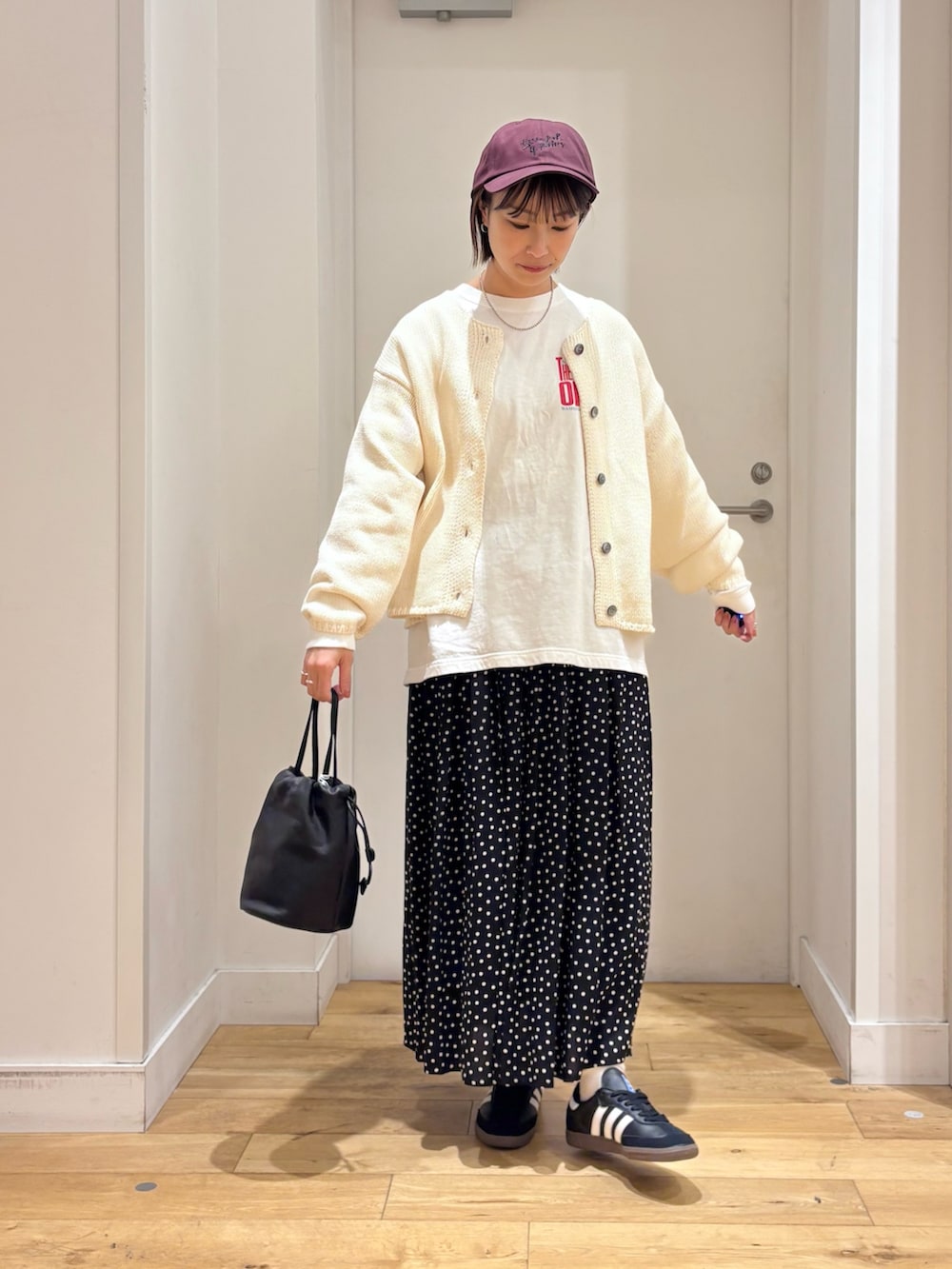 ホワイト系のカーディガン/ボレロ、ブラック系のバッグ、ブラック系のスカートを着用したレディースの冬コーディネートの3枚目の写真