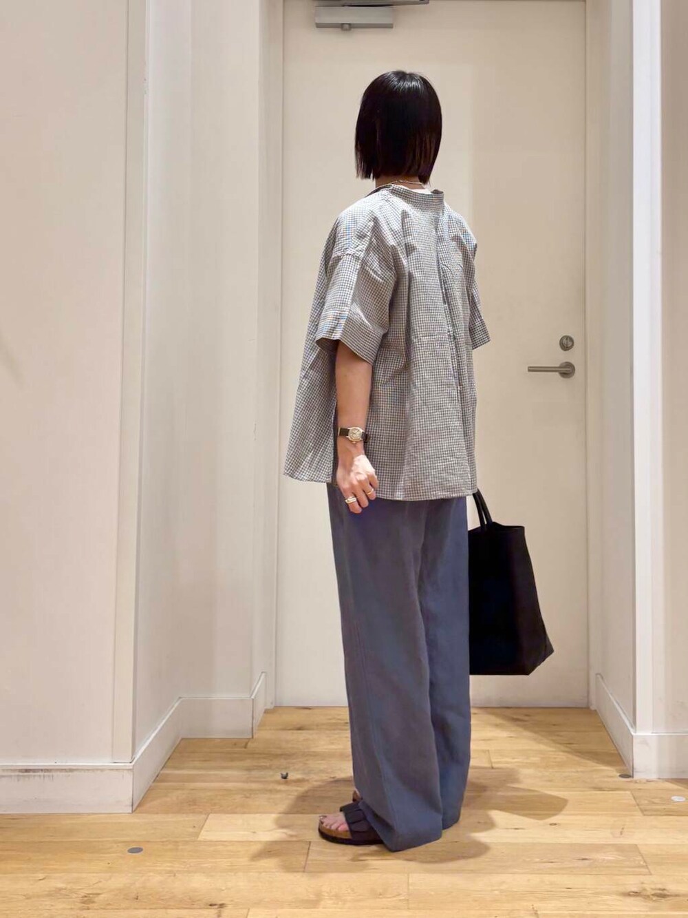 ブラック系のトートバッグ、グレー系のサンダル、ブルー系のその他パンツを着用したレディースの夏コーディネートの7枚目の写真