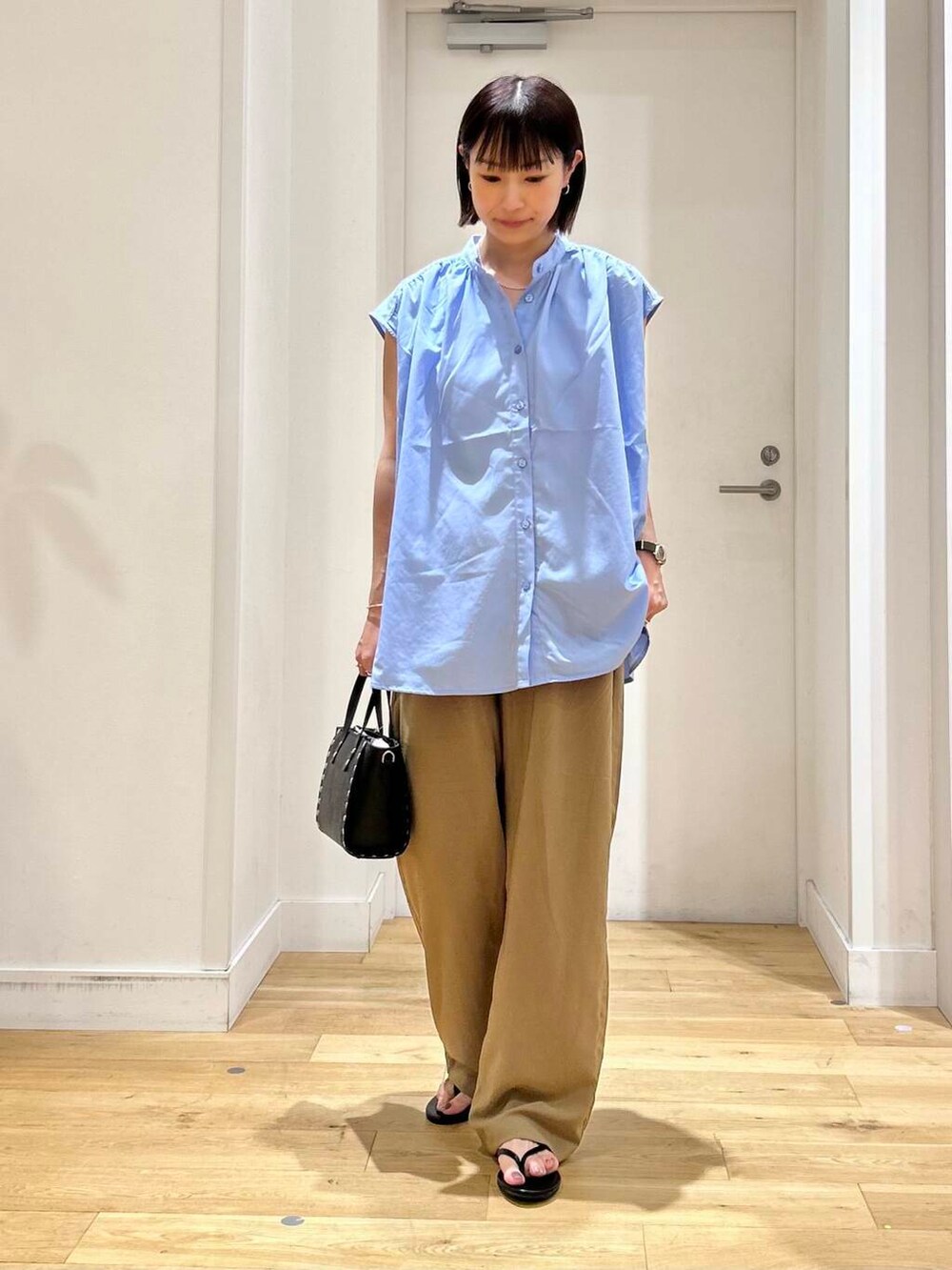 ブラック系のサンダル、ブラック系のショルダーバッグ、ブルー系のシャツ/ブラウスを着用したレディースの夏コーディネートの3枚目の写真