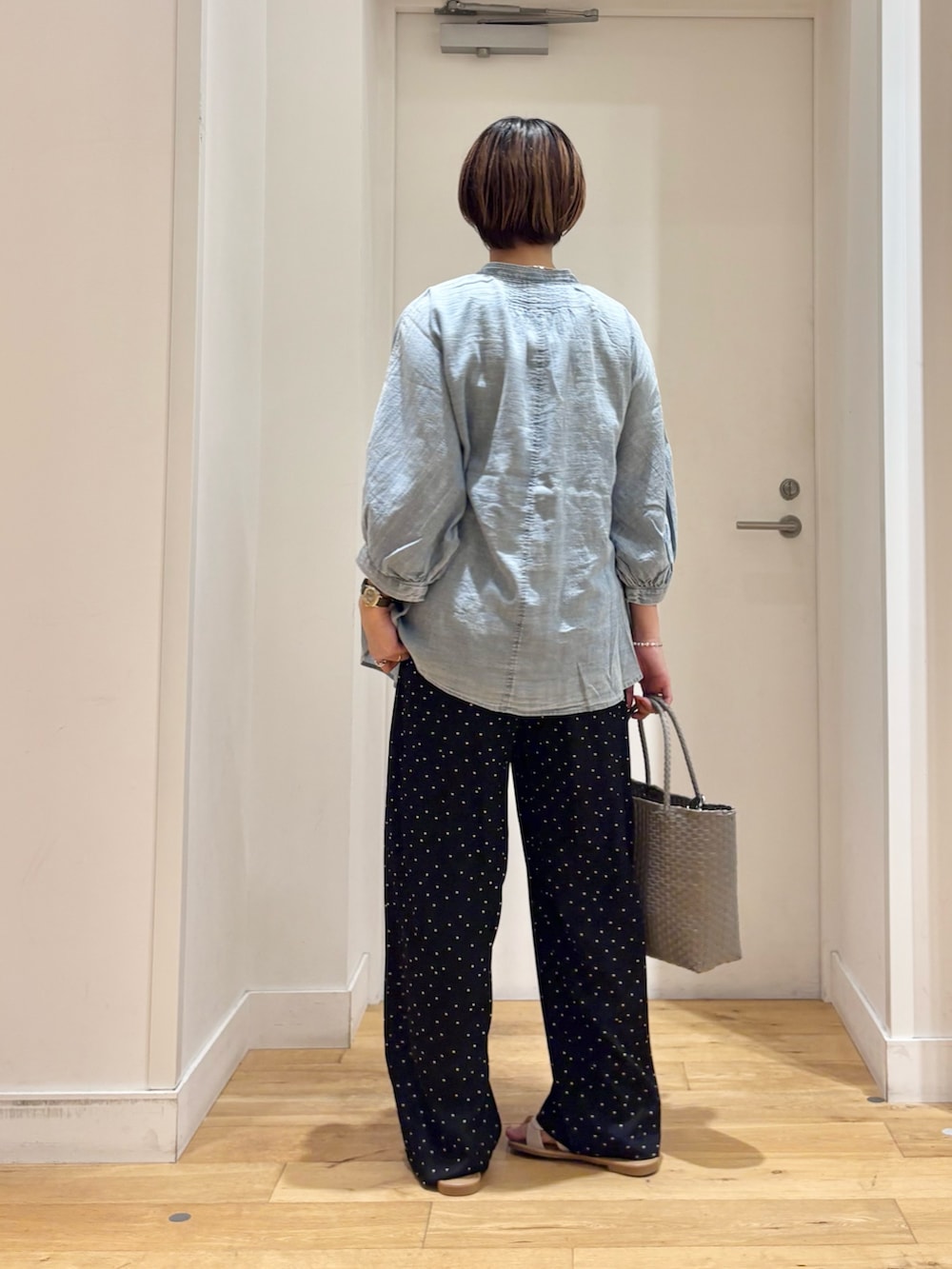 ブラック系のその他パンツ、グレー系のかごバッグ、ホワイト系のサンダルを着用したレディースの夏コーディネートの5枚目の写真