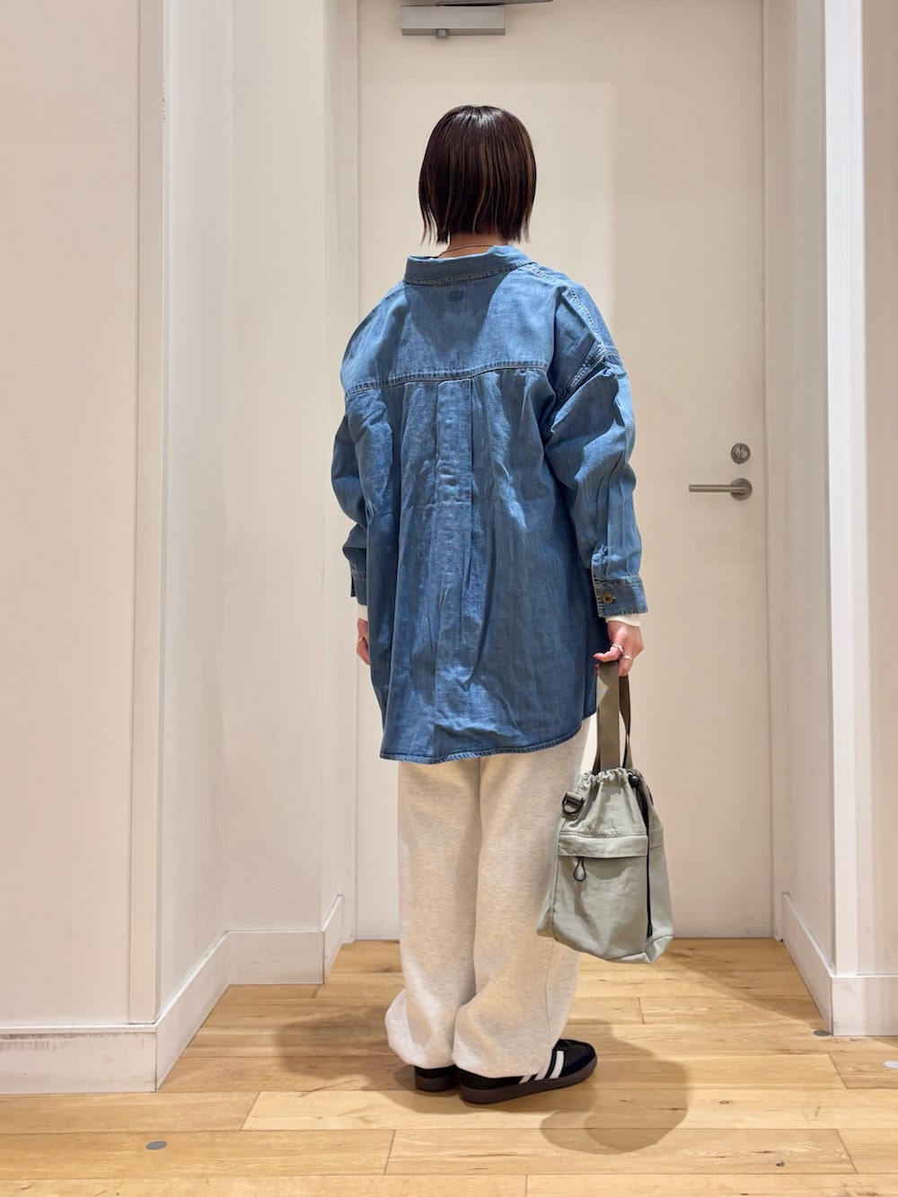 グレー系のその他パンツ、ブルー系のショルダーバッグ、ブラック系のスニーカーを着用したレディースの冬コーディネートの7枚目の写真